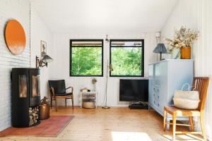 a living room with a fireplace and a tv at The Red Summer House With The Lush Garden At Asnæs in Asnæs