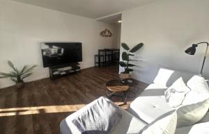 a living room with a white couch and a flat screen tv at Ferienwohnung Gipfelstürmer in Blaichach