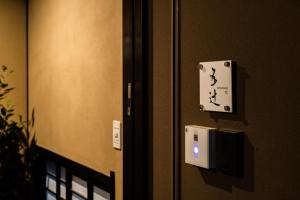 una porta con un interruttore e un cartello su un muro di Nishijin Itsutsuji a Kyoto Altre 24 foto