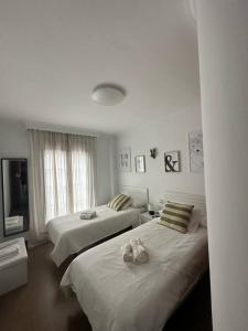 a bedroom with two beds with stuffed animals on them at El pasaje Apart in Ronda