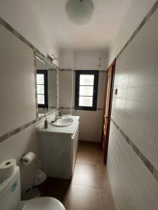 a bathroom with a sink and a toilet and a mirror at El pasaje Apart in Ronda