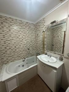 a bathroom with a sink and a bath tub at El pasaje Apart in Ronda +11 photos