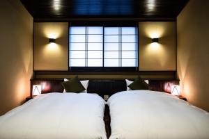 una camera con due letti bianchi e una finestra di Nishijin Itsutsuji a Kyoto