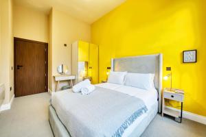 a bedroom with a large bed with a yellow wall at Spacious Central Station 2 Bed Apartment B3 in Glasgow