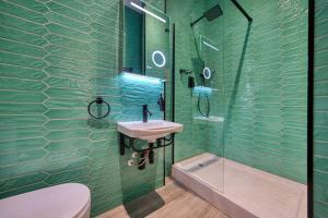 a green bathroom with a sink and a shower at Spacious Central Station 2 Bed Apartment B3 in Glasgow +2 photos