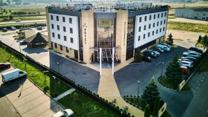 een bovenaanzicht van een groot gebouw met een parkeerplaats bij Hotel Szyszko in Suwałki