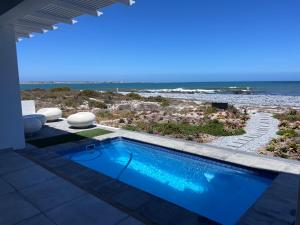 a swimming pool with a view of the beach at Shelley Point On Sea in St. Helena Bay