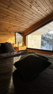 a room with a bed and a large window at Карпатське Hygge котедж для двох з чаном-джакузі у горах in Slavske