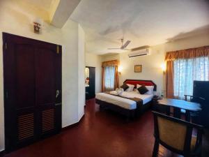 a bedroom with a bed and a desk in a room at Mangotree Kochi in Cochin