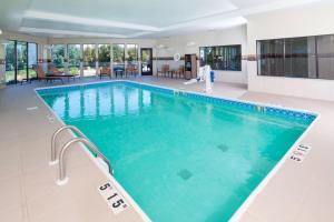 a large swimming pool with blue water in a building at Courtyard by Marriott Battle Creek in Battle Creek