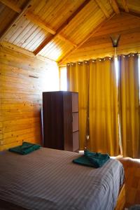 a bedroom with a bed in a wooden cabin at Sameer beachfront Cottages in Canacona