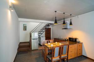 a kitchen and dining room with a table and a staircase at Apartment Collection in Phum Pobos