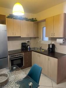 a kitchen with wooden cabinets and a blue chair at Apartments Paradiso Verde in Eretria