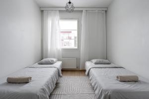 two beds in a room with a window at Lakefront 2BR Home with Sauna near Railway Station & Downtown in Jyväskylä