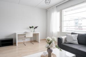 a white living room with a couch and a table at Lakefront 2BR Home with Sauna near Railway Station & Downtown in Jyväskylä +9 photos