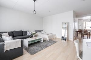a white living room with a black couch and a table at Lakefront 2BR Home with Sauna near Railway Station & Downtown in Jyväskylä