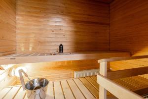 a sauna with a bench and a bottle of wine at Lakefront 2BR Home with Sauna near Railway Station & Downtown in Jyväskylä