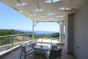 a dining room with a table and chairs on a balcony at Villa Selene in Alonnisos Old Town