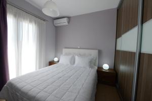 a bedroom with a white bed and a window at Villa Selene in Alonnisos Old Town