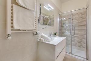 a white bathroom with a sink and a shower at Rooms Vidar Train Station in Marghera