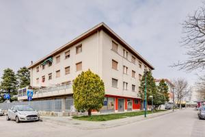 a white building with a car parked in front of it at Rooms Vidar Train Station in Marghera