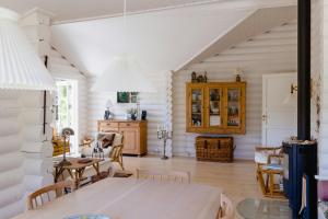 une salle à manger avec des murs blancs, une table et des chaises dans l'établissement Beautiful And Romantic Cottage With Swimmingpool, à Melby