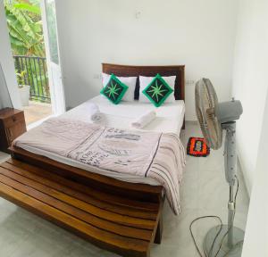 uma cama num quarto com uma ventoinha ao lado em Broad view em Ella
