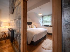 a bedroom with a large bed and a window at Padstow Escapes - Teyr Luxury Penthouse Apartment in Padstow