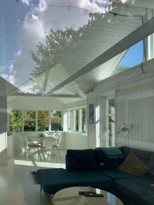a living room with a blue couch and a table at Cozy Red Cottage By Kalø Vig With Seaview in Hornslet