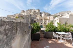 a terrace with a table and chairs in front of a city at Gradelle San Nicola in Matera