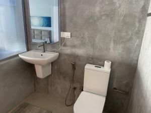 a bathroom with a white toilet and a sink at Blue Maalu Resort in Ambalangoda +168 photos