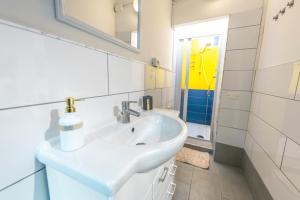 a white bathroom with a sink and a shower at Borghetto Nora 3 in Gravina di Catania