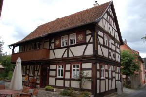 un edificio antiguo con una mesa y una sombrilla en Ferienhaus Austragshaus, en Stockheim