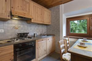 a kitchen with wooden cabinets and a stove top oven at La Baita in Temù