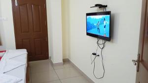 a flat screen tv hanging on a wall in a room at Sethu Residency in Dindigul