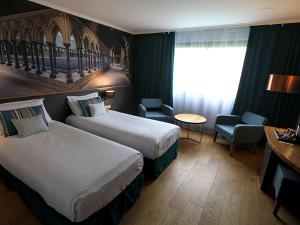 Ein Bett oder Betten in einem Zimmer der Unterkunft Mercure Mont Saint Michel