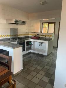 eine große Küche mit weißen Geräten und Fliesenboden in der Unterkunft Condominio Stoneville in São Sebastião