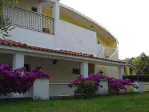 a house with purple flowers in front of it at Ferouli Residence in Rizá