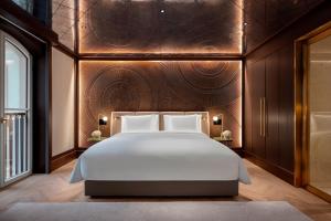 ein Schlafzimmer mit einem großen Bett mit einer Holzwand in der Unterkunft Almanac Palais Vienna in Wien