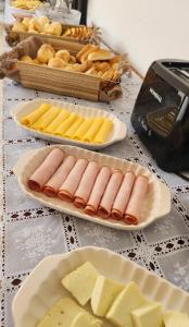 a table topped with plates of food and cheese at Pousada Noa in Cabo Frio