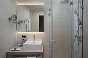 a bathroom with a sink and a shower at NH Trieste in Trieste