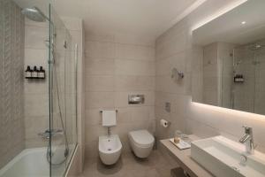 a bathroom with a toilet and a sink and a shower at NH Trieste in Trieste