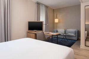 a hotel room with a bed and a television at NH Trieste in Trieste