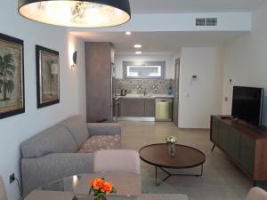 un soggiorno con un divano e un tavolo di Villa Amalia II - Heated Pool, Sauna & Jacuzzi a Torrevieja