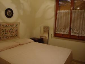 a bedroom with a white bed and a window at Villa Sofia San Ciro 401 in Ulmi