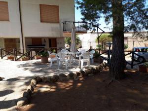 a patio with a table and chairs next to a tree at Villa Sofia San Ciro 401 in Ulmi +13 photos