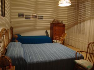 a bedroom with a blue bed and a dresser at Villa Sofia San Ciro 401 in Ulmi