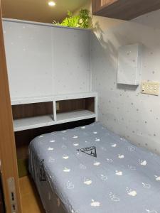 東京にある平安旅馆男士迷你单身公寓の小さなベッドルーム(ベッド1台、棚付)