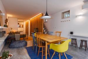 una sala da pranzo e un soggiorno con tavolo e sedie in legno di Modern & Hidden Apartment by LovelyStay a Lisbona Altre 35 foto