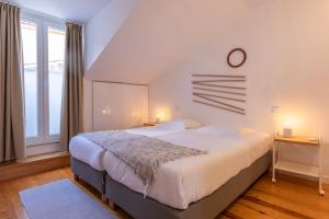 una camera da letto con un letto e un orologio a parete di Modern & Hidden Apartment by LovelyStay a Lisbona